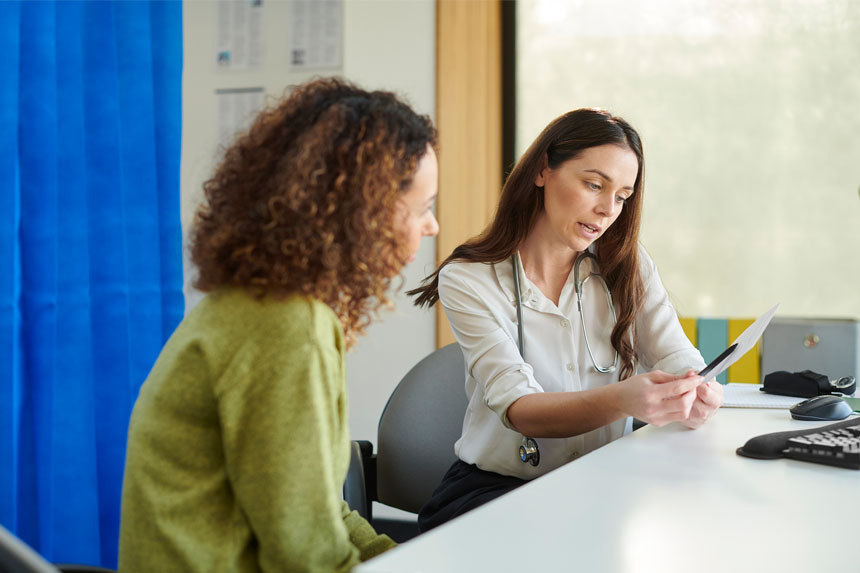 A patient and healthcare professional review test results while sitting at a desk together